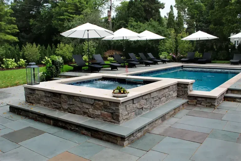 Outdoor hot tub with waterfall into inground pool