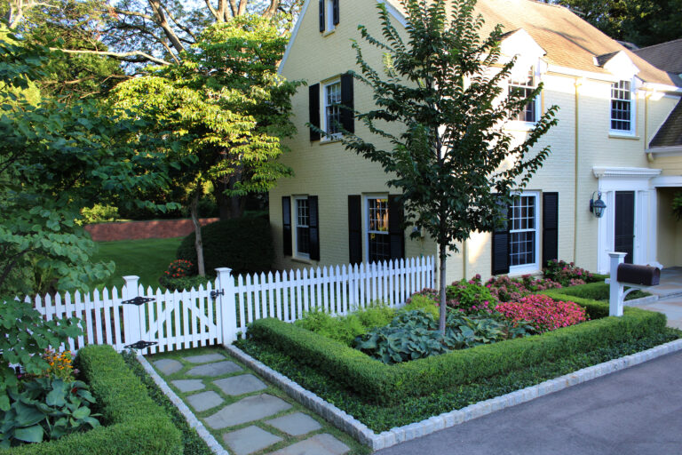 Boxwood hedge Picket fence and stepping stones