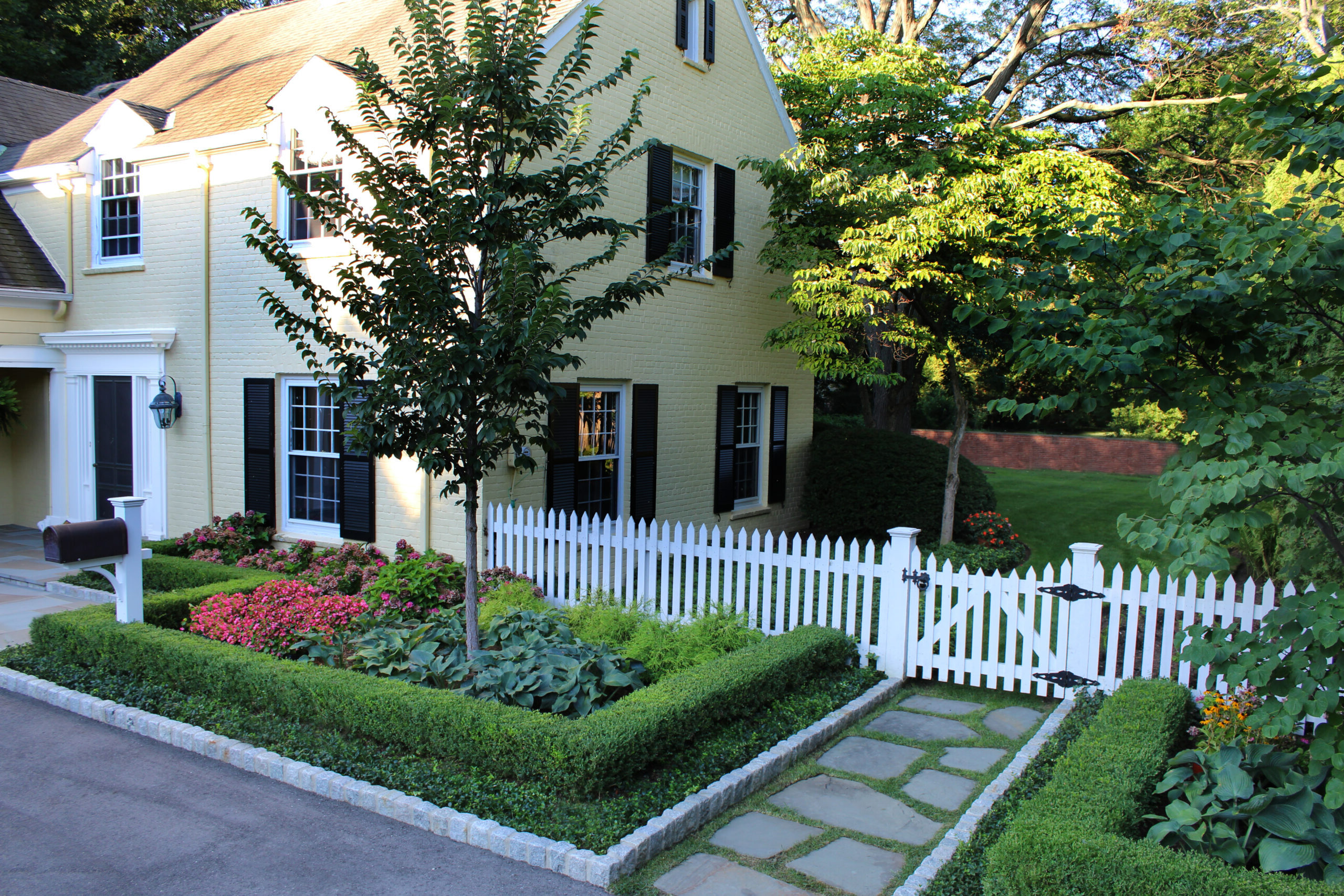 Boxwood hedge Picket fence and stepping stones
